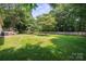 Large, well-maintained backyard with privacy fence, lush lawn, and mature shade trees, perfect for outdoor activities at 10206 Washam Potts Rd, Cornelius, NC 28031