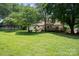 Expansive backyard with lush lawn and mature trees includes a covered deck and space to entertain at 10206 Washam Potts Rd, Cornelius, NC 28031