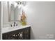 Elegant half-bathroom with a decorative mirror, granite countertop, and stylish vanity at 10206 Washam Potts Rd, Cornelius, NC 28031