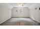 Bedroom features a bright window, neutral colored walls, and plush carpet at 10206 Washam Potts Rd, Cornelius, NC 28031
