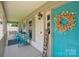 Inviting front porch with seating and a charming turquoise front door adorned with a wreath at 10206 Washam Potts Rd, Cornelius, NC 28031