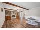 Open living room with hardwood floors, wood beam details, fireplace, and a ceiling fan at 10206 Washam Potts Rd, Cornelius, NC 28031