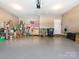 A well-lit garage with painted floors and ample storage, including lawn care equipment and other accessories at 1109 Saratoga Blvd, Indian Trail, NC 28079
