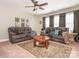 Living room featuring two reclining sofas, a ceiling fan, and a round wood coffee table at 1109 Saratoga Blvd, Indian Trail, NC 28079
