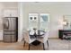 Bright dining area featuring a dark round table, four chairs, and natural light from two windows at 1120 Idyllic Ln, Waxhaw, NC 28173