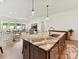 Kitchen island with stainless appliances, barstool seating, and an open view to the living room area at 1120 Idyllic Ln, Waxhaw, NC 28173
