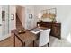 Bright home office features stylish decor, wooden desk, and easy access to the stairway through open french doors at 1120 Idyllic Ln, Waxhaw, NC 28173