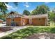 Back exterior view of brick home featuring well maintained lawn, and private driveway at 1219 Flowe Dr, Matthews, NC 28104