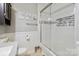 Bathroom featuring white tile shower with glass door, built-in niche, and white wainscoting at 1219 Flowe Dr, Matthews, NC 28104