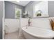 Relaxing bathroom features a soaking tub, wainscoting, and modern fixtures at 1219 Flowe Dr, Matthews, NC 28104