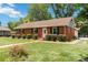 Charming brick home with manicured lawn, lush shrubbery, and welcoming front entrance at 1219 Flowe Dr, Matthews, NC 28104