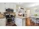 Updated kitchen features stainless steel appliances, stone countertops, and a mosaic backsplash at 1219 Flowe Dr, Matthews, NC 28104
