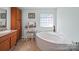 Serene bathroom featuring a vanity, corner bathtub, and unique glass block window at 130 Benton Rd, Kings Mountain, NC 28086