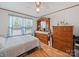 Bright bedroom with hardwood floors, ceiling fan, and traditional wood furniture and a sunny window with blue curtains at 130 Benton Rd, Kings Mountain, NC 28086