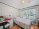 This cozy bedroom has hardwood floors, a ceiling fan, window with blue curtains and a full sized bed and desk at 130 Benton Rd, Kings Mountain, NC 28086