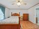 Well-lit bedroom with wood flooring, a classic wood bed frame, dresser, and soft curtains at 130 Benton Rd, Kings Mountain, NC 28086