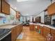 Open kitchen layout with wooden cabinets, laminate countertops, and wood-look flooring extending to the dining area at 130 Benton Rd, Kings Mountain, NC 28086