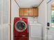 This laundry area features a red washer and dryer with cabinets above for extra storage at 130 Benton Rd, Kings Mountain, NC 28086