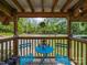 Enjoy outdoor living on this covered porch with a small table set and views of a lush yard and street at 130 Benton Rd, Kings Mountain, NC 28086