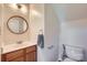 A half bathroom featuring a wood vanity, modern faucet, and round mirror above sink at 130 Ridge Bluff Rd, Mooresville, NC 28115