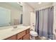 Bathroom features a vanity with a white sink, a round mirror, and a tub with a shower curtain at 130 Ridge Bluff Rd, Mooresville, NC 28115