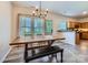 Bright dining area featuring a large wooden table, a modern chandelier, and access to the kitchen at 130 Ridge Bluff Rd, Mooresville, NC 28115