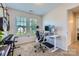 Home office with a built-in desk, a keyboard, two guitars and natural light from a large window at 130 Ridge Bluff Rd, Mooresville, NC 28115