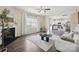 Bright living room with fireplace, ceiling fan, hardwood floors, and a view into the kitchen at 154 King William Dr, Mooresville, NC 28115