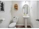 Cozy powder room with wood floors, pedestal sink, modern fixtures, and decorative mirror at 154 King William Dr, Mooresville, NC 28115