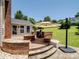 Backyard featuring a brick patio with a grill, fire pit, and green lawn area at 165 Cottontail Se Ln, Concord, NC 28025