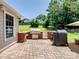 Outdoor brick patio with a built-in kitchen area featuring a grill and lush green surroundings at 165 Cottontail Se Ln, Concord, NC 28025