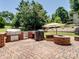 Paver patio with grill, fire pit, and large shade umbrella surrounded by green lawn and trees at 165 Cottontail Se Ln, Concord, NC 28025