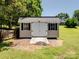 Backyard shed with gray metal roof, wooden ramp and white double doors for convenient backyard storage at 165 Cottontail Se Ln, Concord, NC 28025