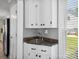 Convenient wet bar featuring white cabinets, granite countertop, and a view to the backyard at 165 Cottontail Se Ln, Concord, NC 28025