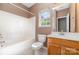 Bathroom features a shower-tub combination, window, vanity with wooden cabinets and tile flooring at 168 Devon Forest Dr, Mooresville, NC 28115