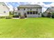 Expansive backyard with a lush lawn, stone patio, outdoor bar, and screened in porch at 17012 Alydar Commons Ln, Charlotte, NC 28278