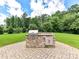 Outdoor stone grill on stone paver patio in fenced backyard at 17012 Alydar Commons Ln, Charlotte, NC 28278