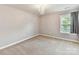 Bedroom with carpet flooring, modern chandelier, and a window for natural lighting at 17012 Alydar Commons Ln, Charlotte, NC 28278