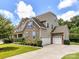 Spacious home boasts a three car garage, a stone facade, and a well-manicured lawn at 17012 Alydar Commons Ln, Charlotte, NC 28278