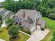 Beautifully designed exterior featuring a brick and stone facade, three car garage, and manicured lawn at 17012 Alydar Commons Ln, Charlotte, NC 28278