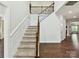 Grand two-story foyer showcases a staircase with iron railing and wood accents, and hardwood floors at 17012 Alydar Commons Ln, Charlotte, NC 28278