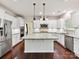 Bright kitchen featuring granite countertops, white cabinetry, stainless steel appliances, and a center island at 17012 Alydar Commons Ln, Charlotte, NC 28278