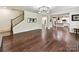 Open-concept living room with hardwood floors leading to the staircase and kitchen at 17012 Alydar Commons Ln, Charlotte, NC 28278