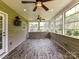 Enclosed sunroom with wood-look flooring, ceiling fans, and multiple windows at 17012 Alydar Commons Ln, Charlotte, NC 28278