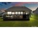 View of the backyard featuring a wooden deck with dark railings, lawn, and an inviting screened-in porch at 17733 Burnt Hickory Dr, Charlotte, NC 28278