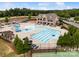 An aerial view of a large community pool with a waterslide, lap lanes, lounge chairs, and shade umbrellas at 17733 Burnt Hickory Dr, Charlotte, NC 28278
