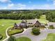 Aerial view of golf club featuring manicured lawns and a stunning clubhouse with stone and architectural details at 17733 Burnt Hickory Dr, Charlotte, NC 28278