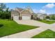 Charming home boasts manicured lawn, stone accents, and a convenient two-car garage, offering a welcoming exterior at 17733 Burnt Hickory Dr, Charlotte, NC 28278