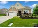 Beautiful home featuring stone accents, a manicured lawn, and a convenient two-car garage enhancing its curb appeal at 17733 Burnt Hickory Dr, Charlotte, NC 28278