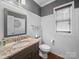 Charming bathroom with wainscoting, a granite-topped vanity, and neutral decor exudes a clean and inviting ambiance at 1808 Mill Chase Ln, Waxhaw, NC 28173